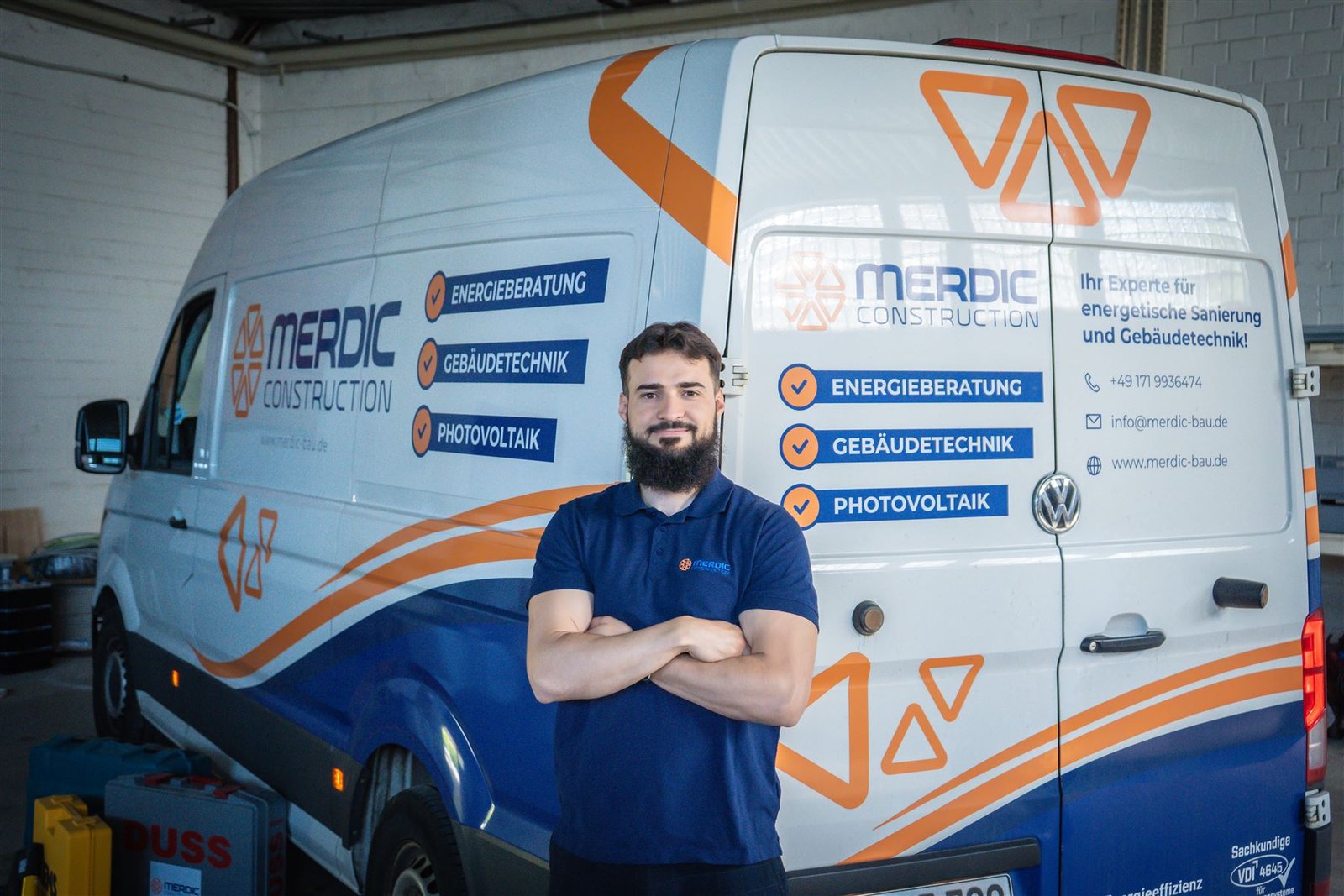 Merdic-Construction-Monteur vor dem Firmentransporter – Energieberatung, Gebäudetechnik, Photovoltaik